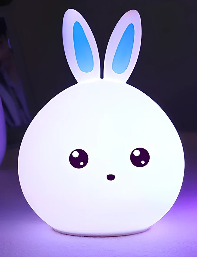 White silicone rabbit night light with USB charging cable showing touch sensor area and colourful LED illumination