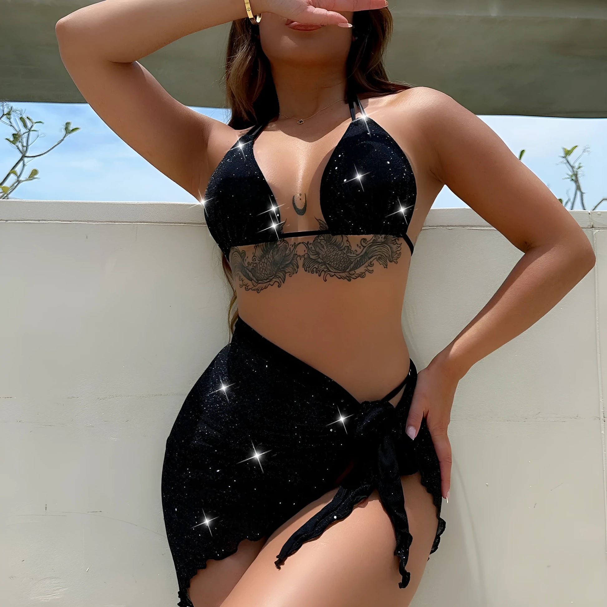 Black three-piece swimsuit bikini set with a top and shorts laid flat.