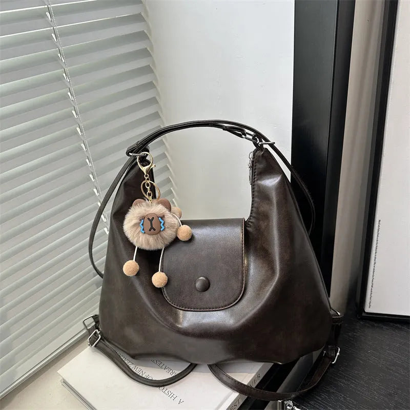 Textured PU leather women's shoulder bag in black with single strap and optional pendant
