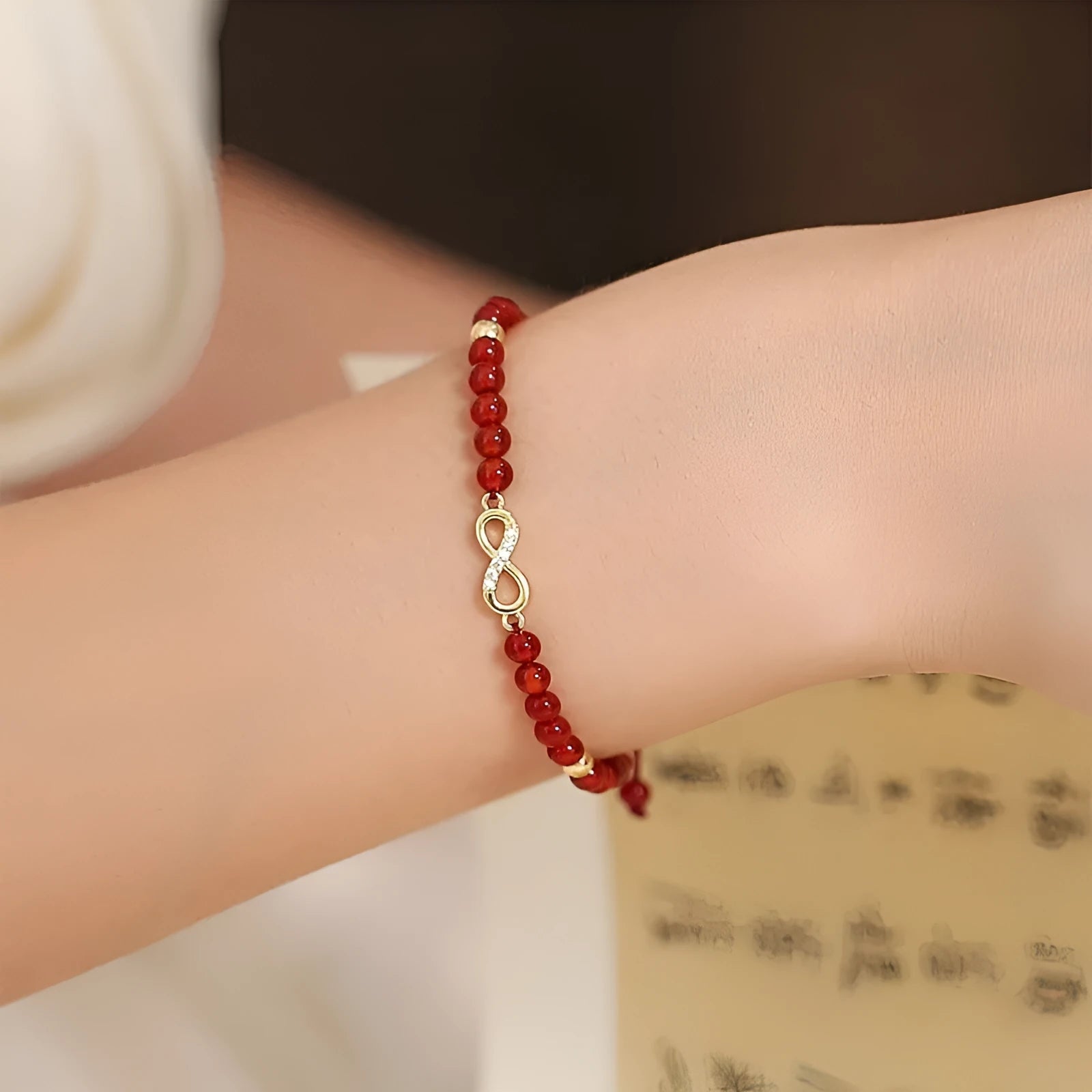 Hand-woven red agate beads bracelet with lucky charm in ethnic style, showing diamond-shaped beads.