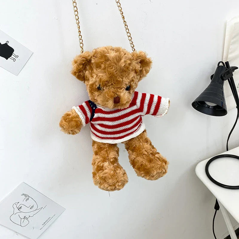 A plush teddy bear crossbody messenger bag with an adjustable shoulder strap and a zippered interior pocket for convenient storage.