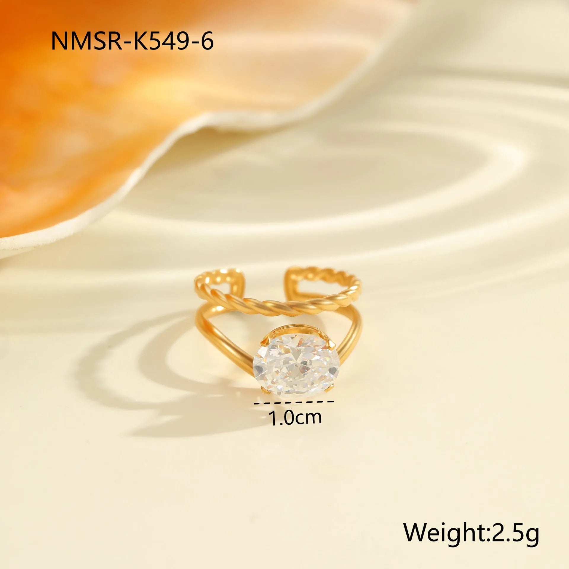 Gold electroplated stainless steel open mouth ring with geometric shapes and zircon inlay on a heart drop.