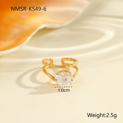 Gold electroplated stainless steel open mouth ring with geometric shapes and zircon inlay on a heart drop.