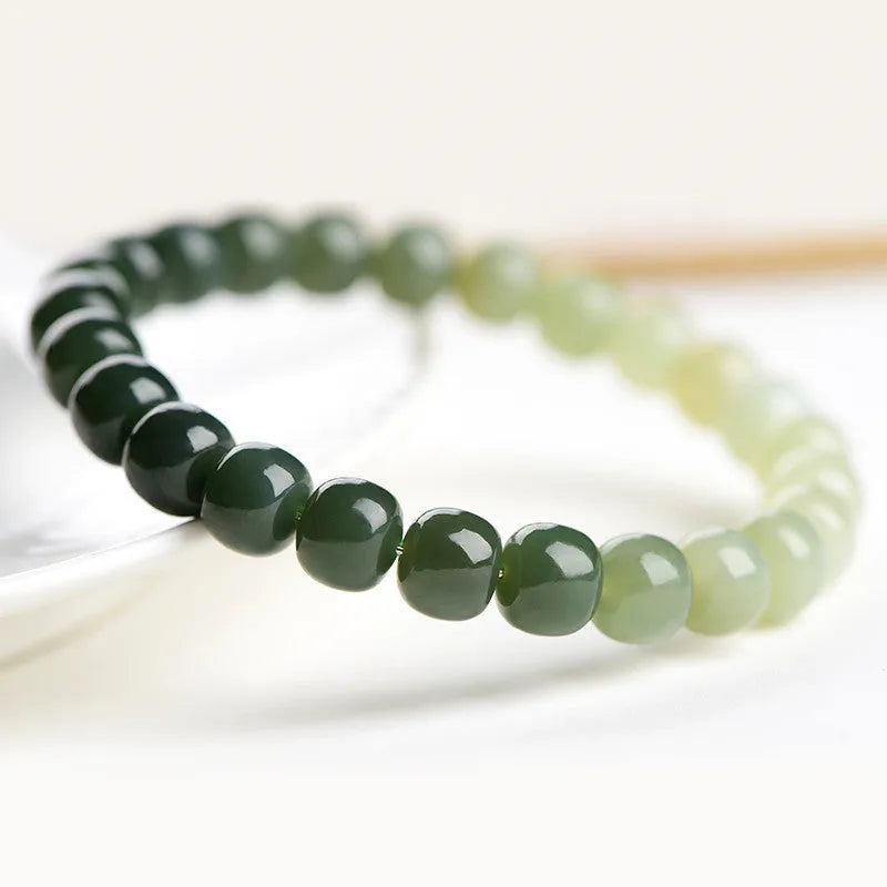 Natural Hetian jade bracelet showing gradient clear water colour on polished beads with either 6x7mm or 7x8mm dimensions