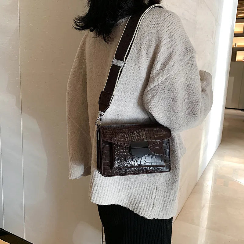Vintage crossbody bag in black showing 20cm width, crossbody strap, and front storage compartment