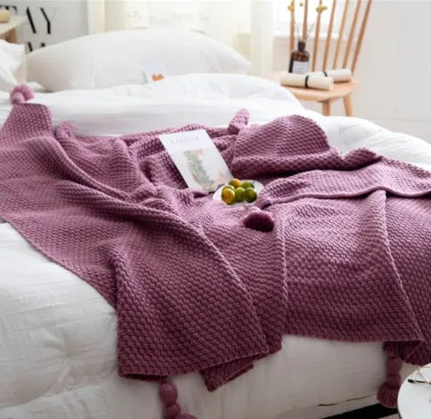 Nordic style fringed knit acrylic blanket in beige colour on a sofa
