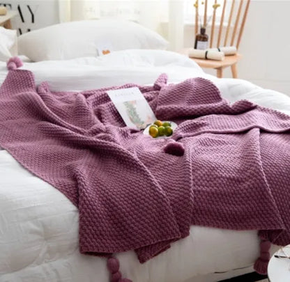 Nordic style fringed knit acrylic blanket in beige colour on a sofa