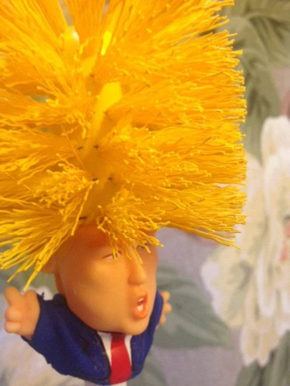Comical Donald Trump-themed toilet brush made of durable plastic with a bold yellow color and convenient hanging slot