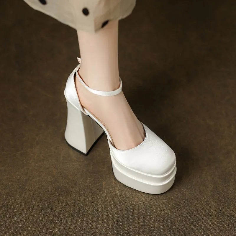 Women's white chunky heel platform pumps with a round toe and mid-calf cut.