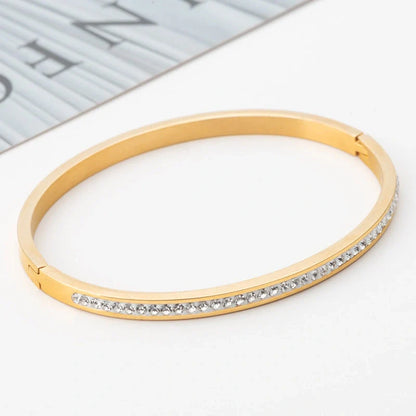 Elegant stainless steel bracelet with diamond accent, available in gold, rose gold, and steel finishes.