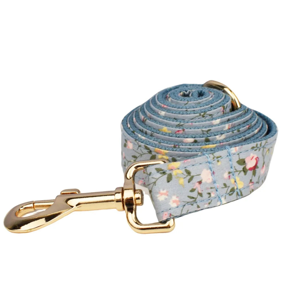 Blue floral dog collar set with adjustable sizes, includes leash, vest, bow, and poop bag on polyester cotton cloth.