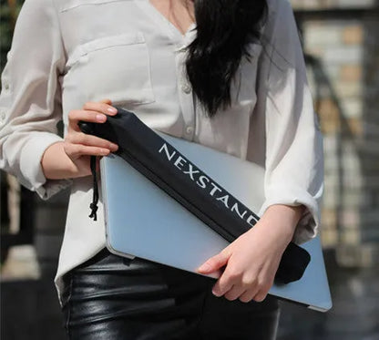 Black folding portable laptop stand with aluminium frame, shown open supporting a laptop and folded to 4cm thickness.