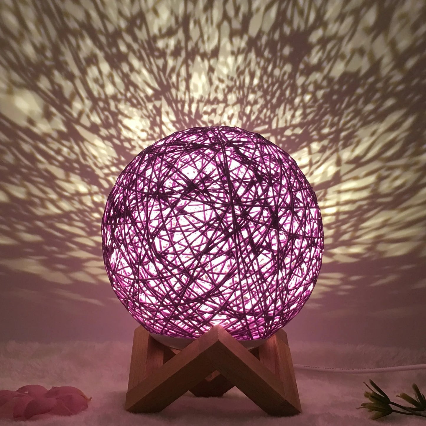 Spherical hand-knitted rattan table lamp with remote control on a wooden desk