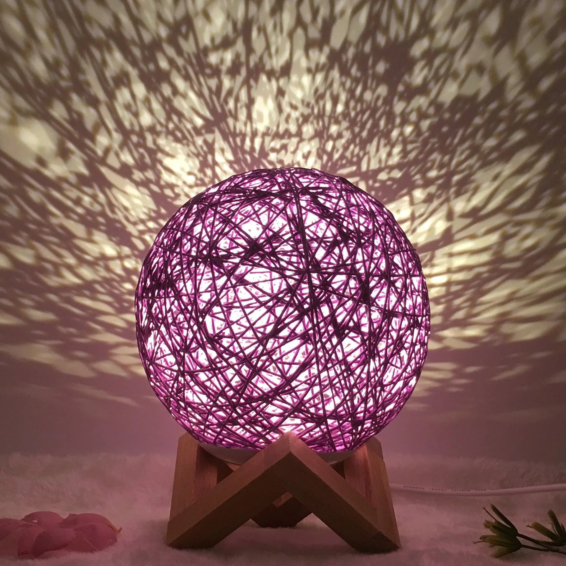 Spherical hand-knitted rattan table lamp with remote control on a wooden desk