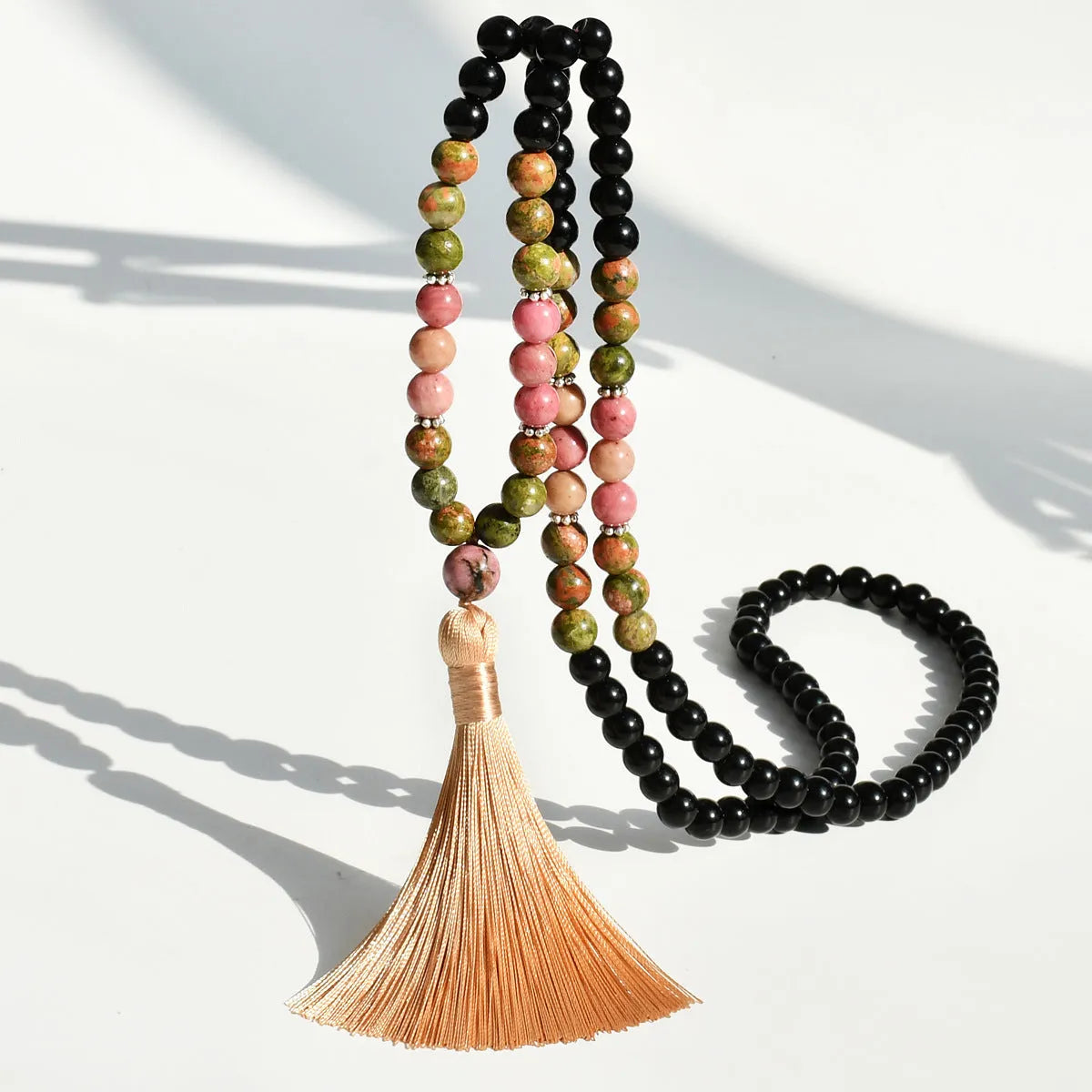 Long beaded necklace with geometric pendant and natural stone tassels in green aventurine.
