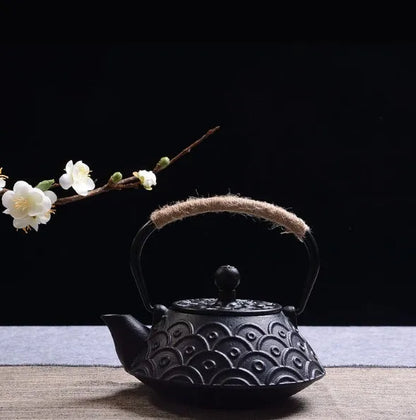 Japanese-style cast iron teapot with lid on a hob, shown in a bronze finish.