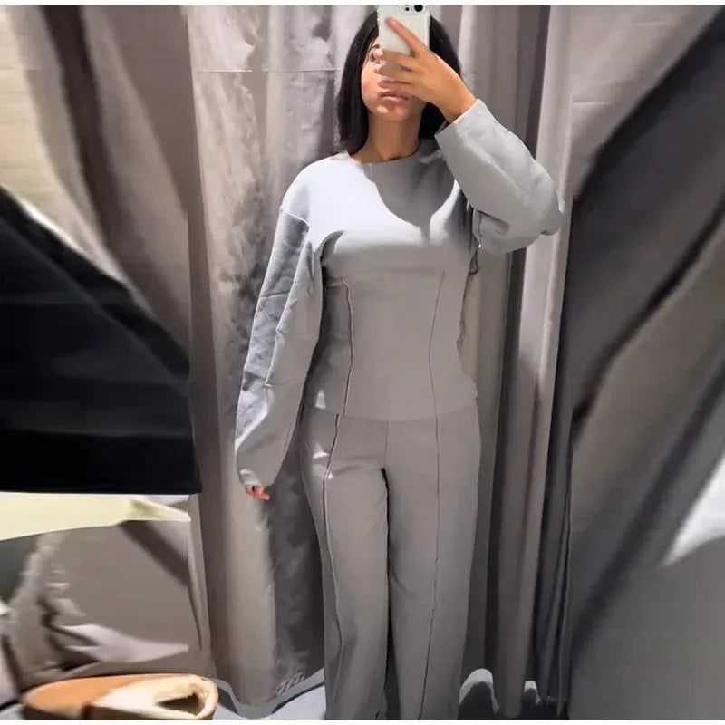 Women's black fleece tracksuit set featuring a pleated long sleeve top and wide leg trousers