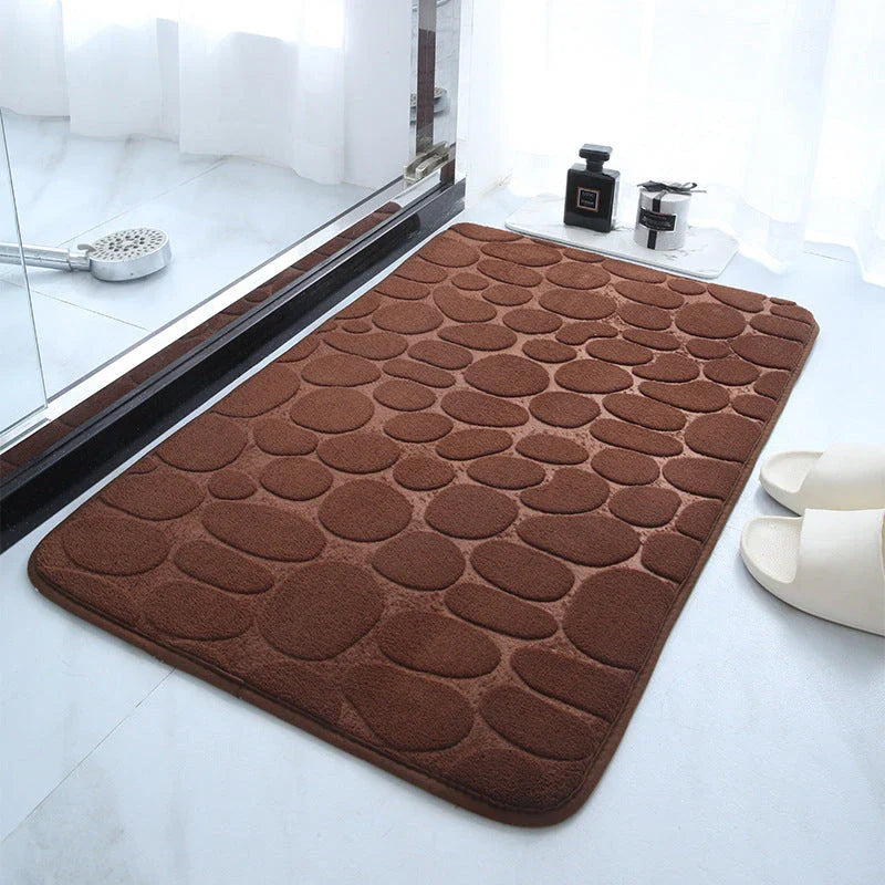 Plush and comfortable memory foam bath mat with cobblestone texture for a soothing, massage-like experience