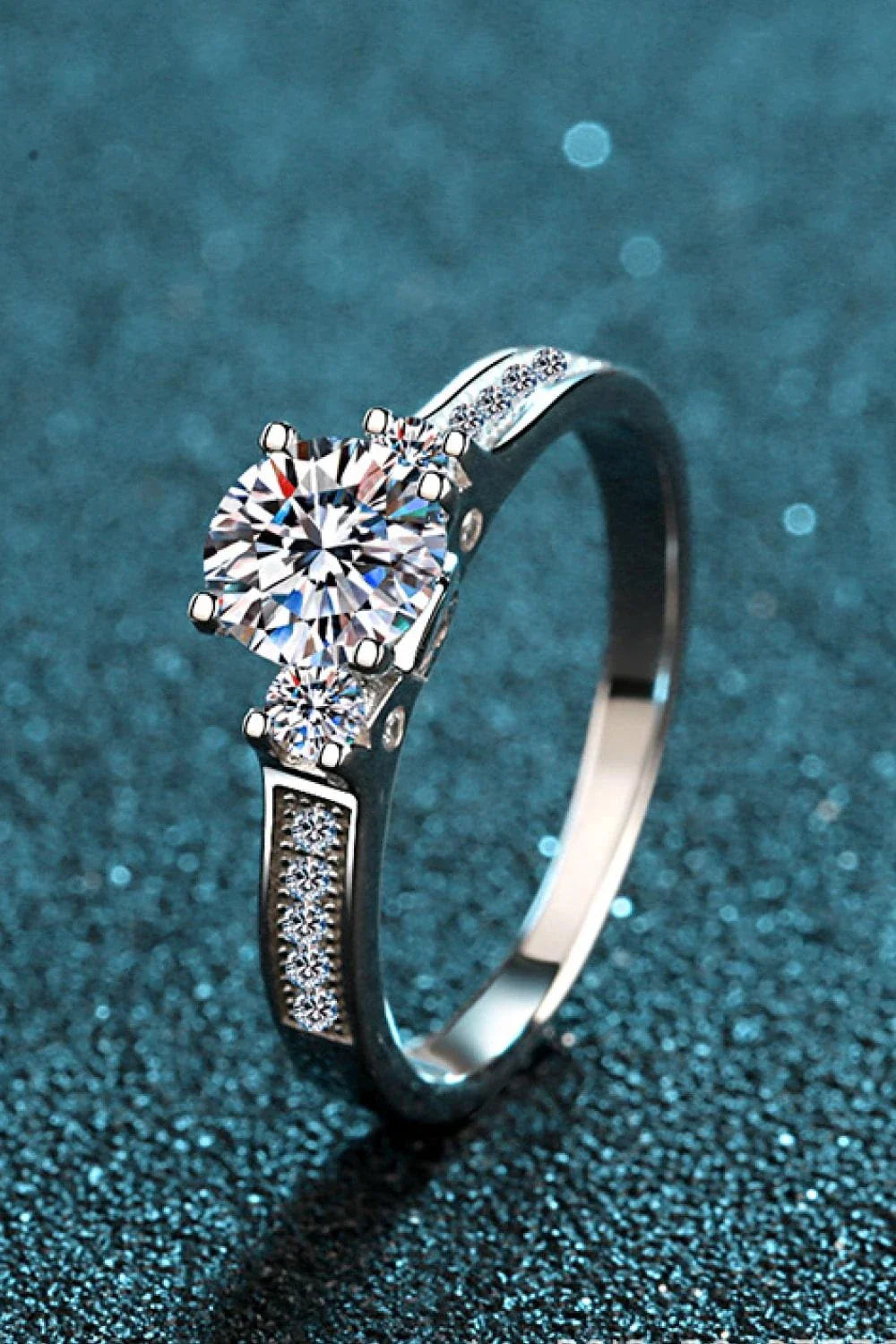 Closeup shot of a sparkling moissanite ring with a rhodium-plated silver band and subtle zircon accent stones