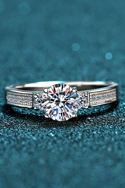 Closeup shot of a sparkling moissanite ring with a rhodium-plated silver band and subtle zircon accent stones
