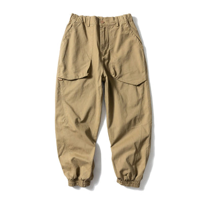 Black cotton casual pants with large pockets, tapered legs, and ankle ties on a hanger.