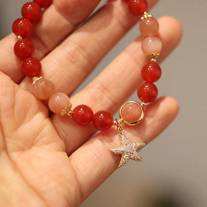 Women's handmade red agate and sunstone bracelet with ethnic charms