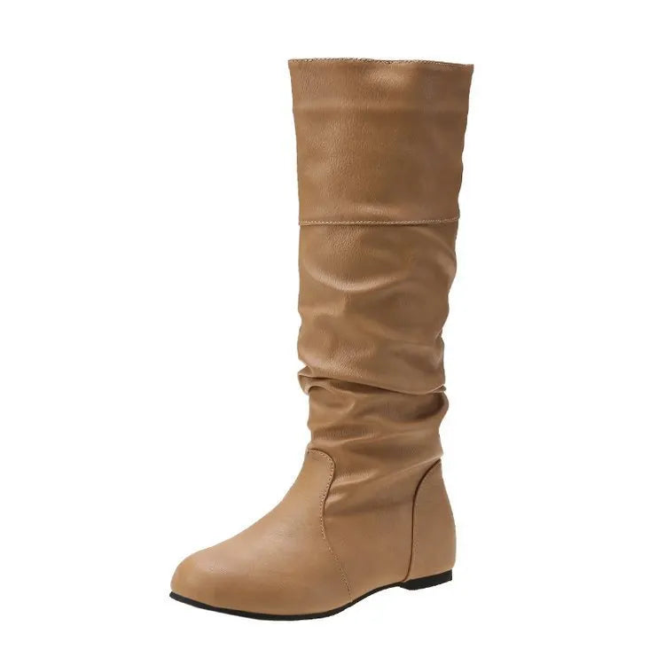 Women's flat slip-on boots in black with round toe and high cylinder shaft on a neutral background.