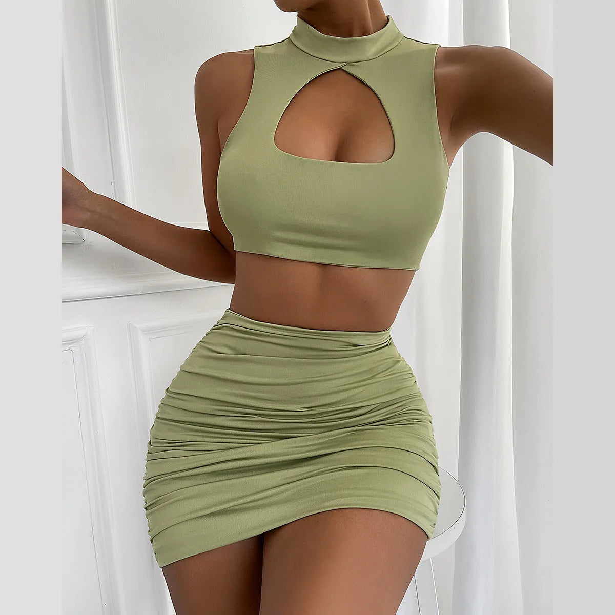Light purple women's two-piece set featuring a hollow vest with cutouts and a high-waisted split skirt on a model.