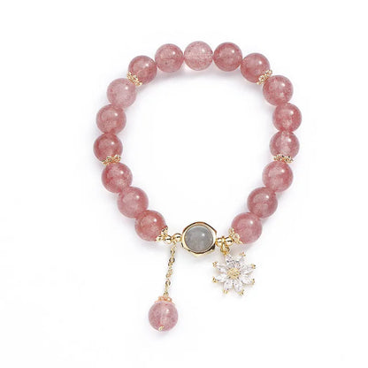 A Mori style crystal bracelet made with natural pink strawberry quartz stones and delicate electroplated floral charms.