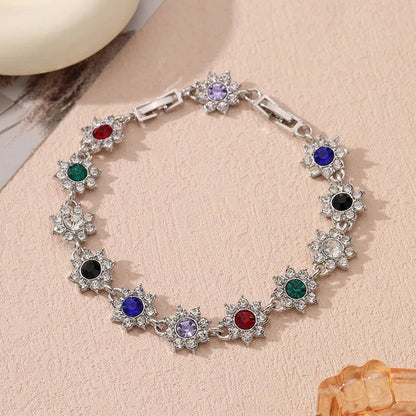 Floral shaped zinc alloy bracelet with electroplated colourful gem finishes in gold and silver tones.