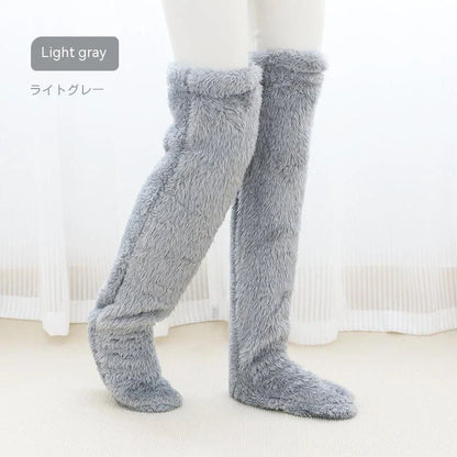 Cozy over-the-knee fuzzy socks in various colors, including brown, blue, dark gray, pink, silver, and more. Comfortable cotton design for warm, snug legs.