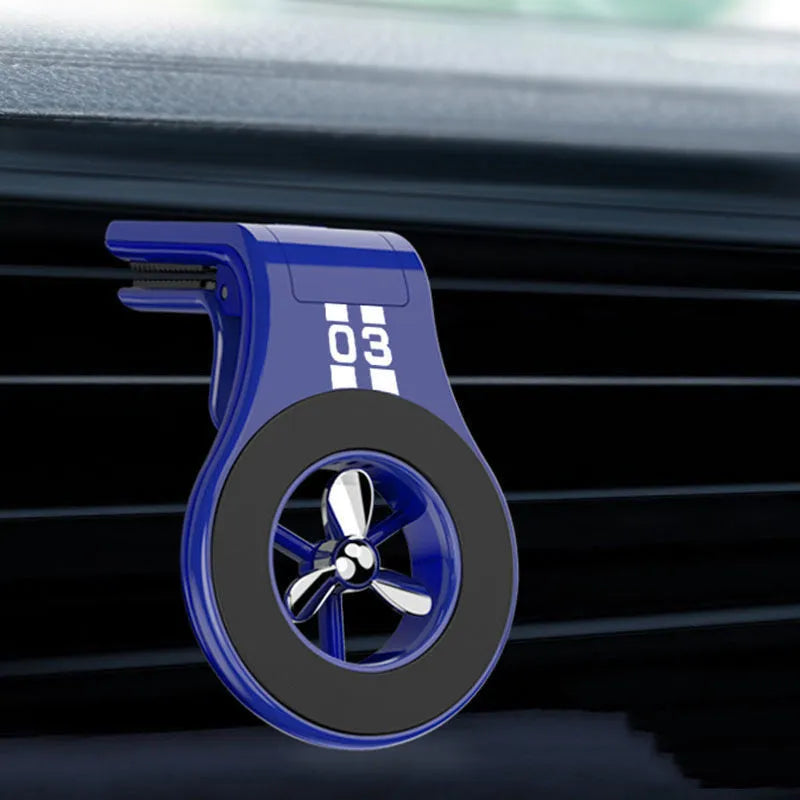 Black magnetic car phone holder attached to air vent with smartphone mounted and fragrance slices visible