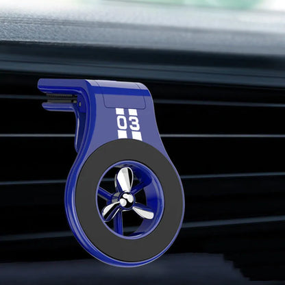 Black magnetic car phone holder attached to air vent with smartphone mounted and fragrance slices visible