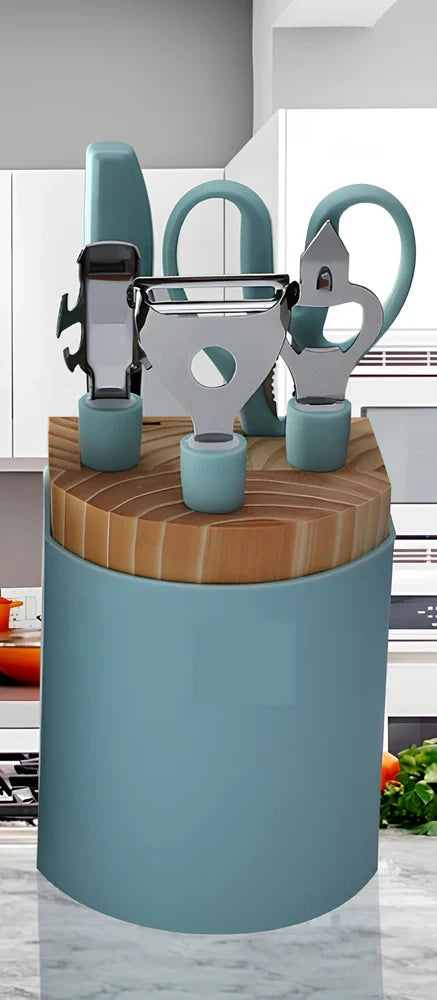 Stainless steel kitchen utensil set with whisk, grater, peeler, scissors and other tools on grey background