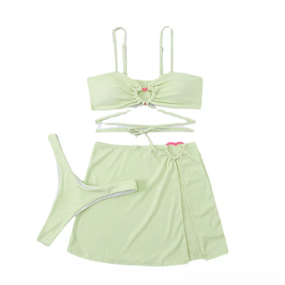Women's three-piece bikini swimsuit with lace heart detail in green, light blue, and rose red