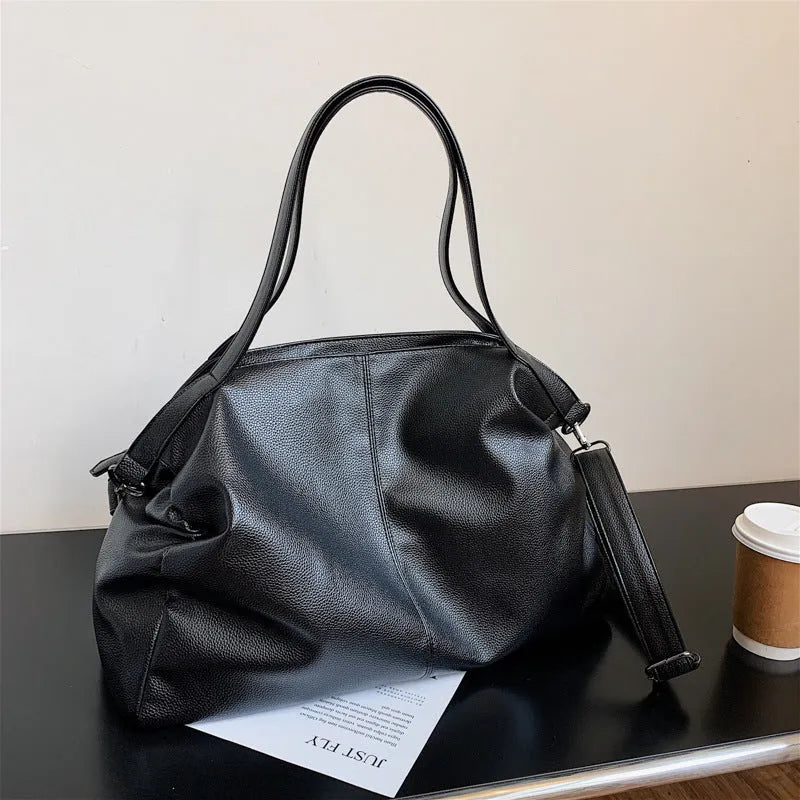 Large soft black PU messenger bag with long shoulder strap and front car suture detailing