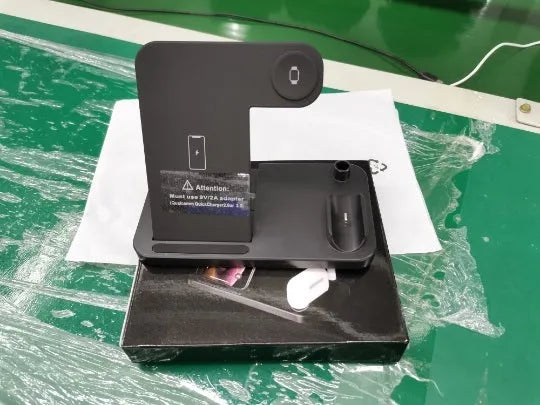 Black folding 4-in-1 wireless charger open, showing iPhone, Apple Watch, AirPods, and Apple Pen charging simultaneously.