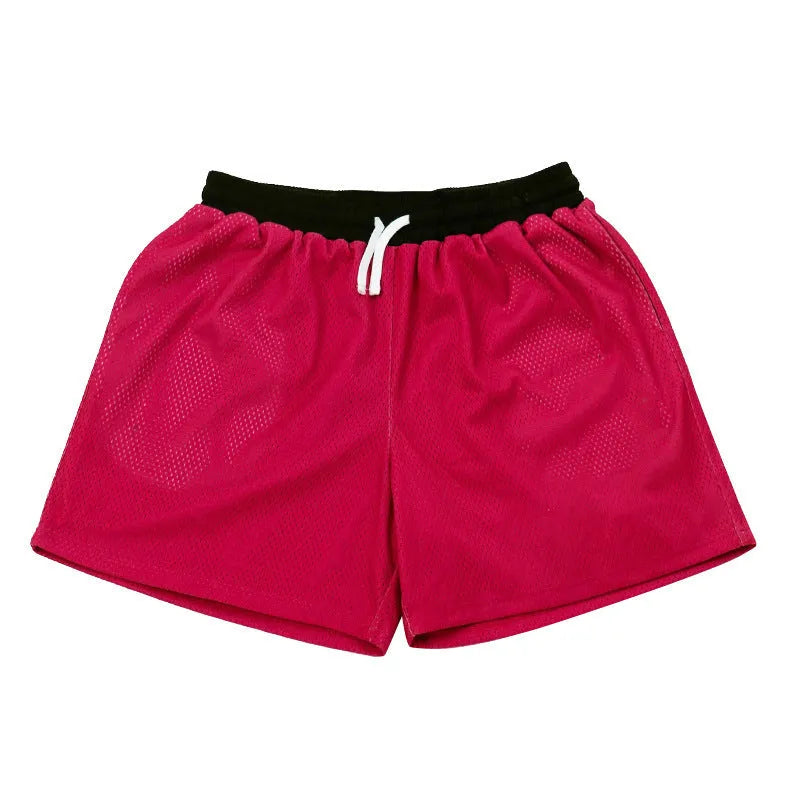 Men's black athletic shorts with grey mesh side panels for breathability, laid flat on a surface.