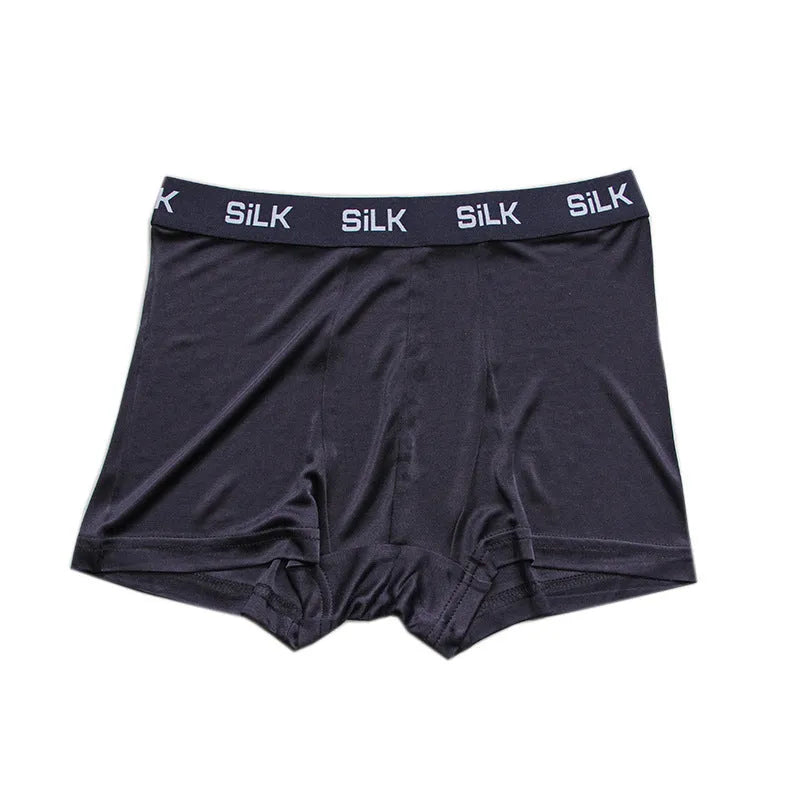 Men's loose-fitting silk shorts in navy blue on a neutral background.
