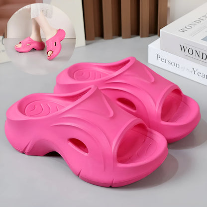 Women's thick-soled EVA foam beach slippers in rose red colour on a sandy background.