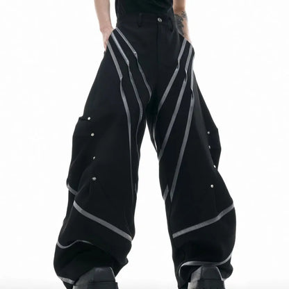 Men's trousers with three-dimensional cutting and metal striped rivet pleats in black or white, showing tailored fit and detail