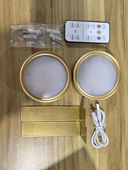 Black magnetic LED painting lamp with remote control on a white wall.