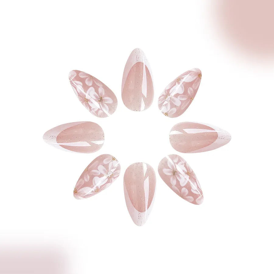Short glossy almond artificial French nails with glitter flower design on white tips