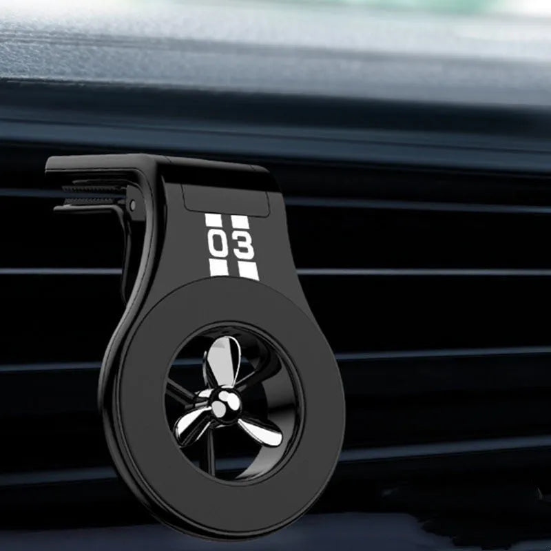 Black magnetic car phone holder attached to air vent with smartphone mounted and fragrance slices visible