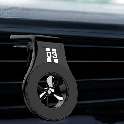Black magnetic car phone holder attached to air vent with smartphone mounted and fragrance slices visible