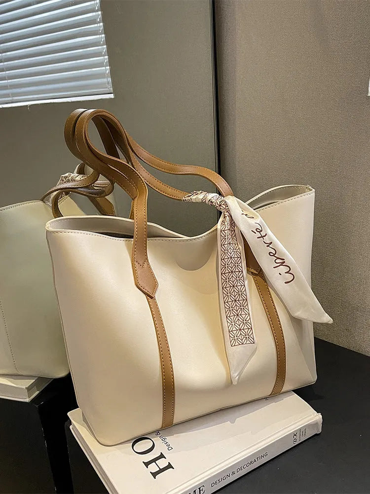 Soft large-capacity bucket tote bag with shoulder strap and zip pocket, shown in a neutral colour.