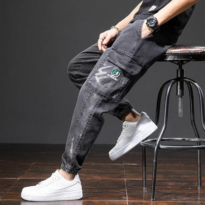 Men's blue cargo jeans with straight-leg fit, micro-elasticity fabric, and cargo pockets on a hanger.