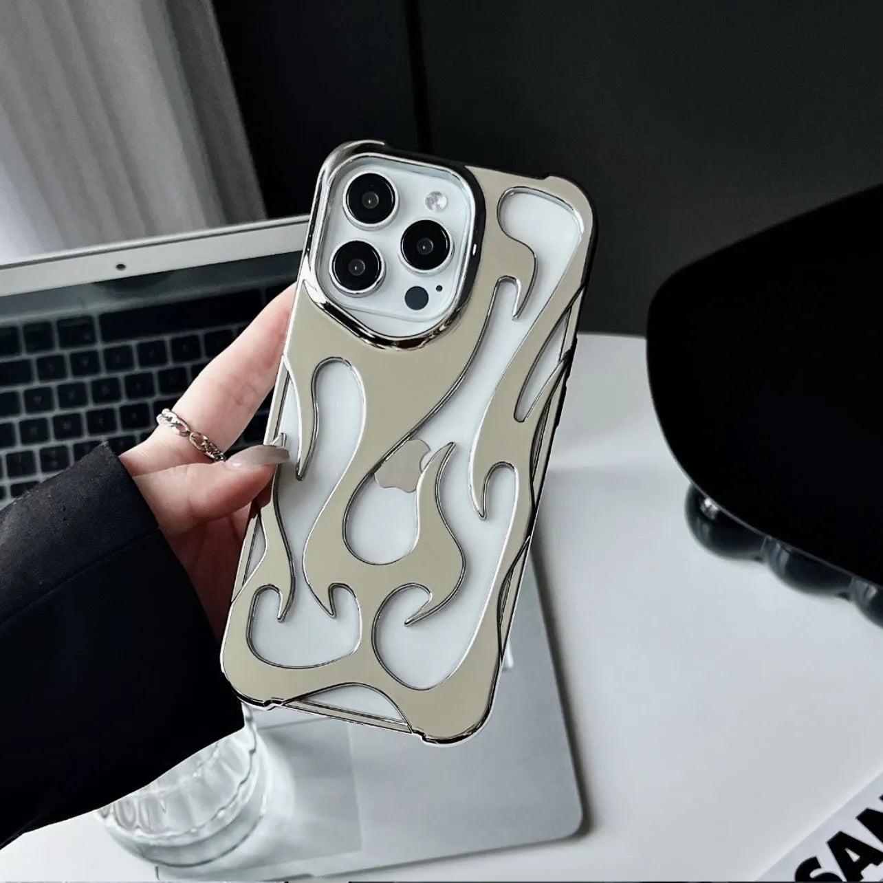 Electroplated hollow flame pattern phone case in silver plated finish on Apple iPhone, showing heat dissipation design and TPU soft shell