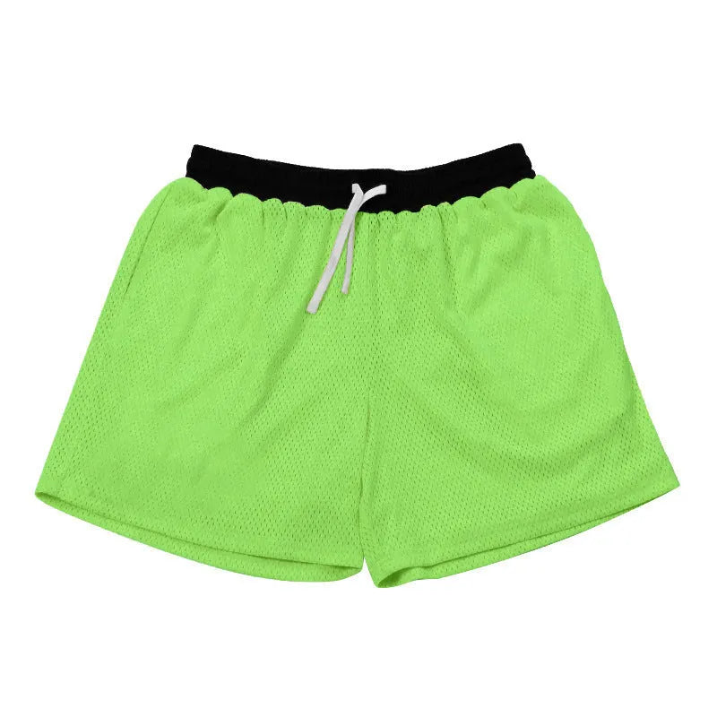 Men's black athletic shorts with grey mesh side panels for breathability, laid flat on a surface.