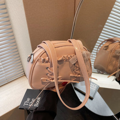 Milky white women's shoulder handbag with a large bandage bow and visible stitching, showing the internal phone pocket.